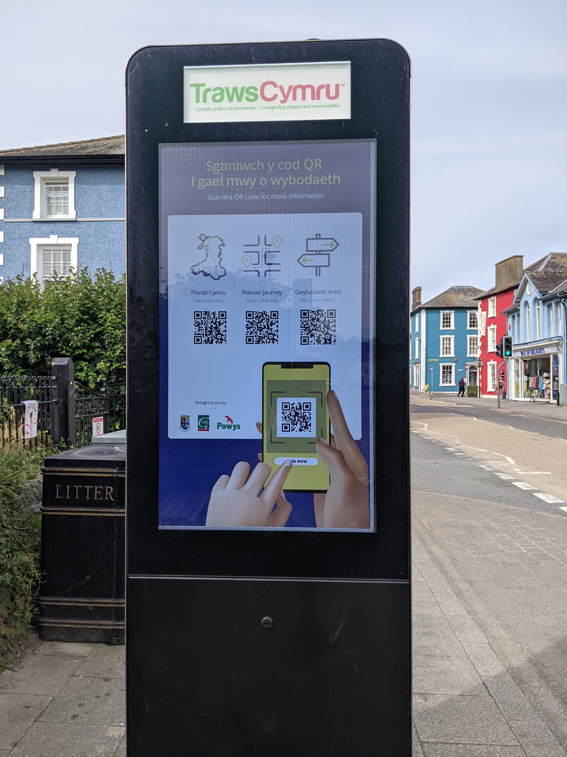 Digital billboard in the street with instructions on how to use an app to find destinations and routes around the local area.